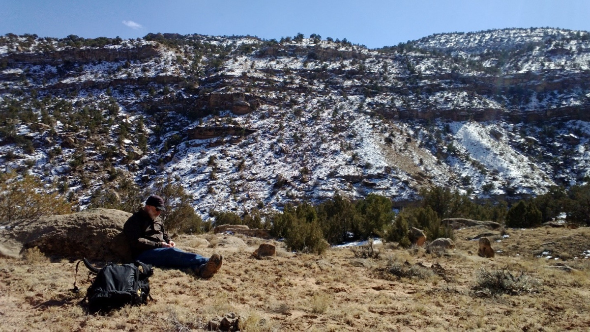 man sitting near rock 