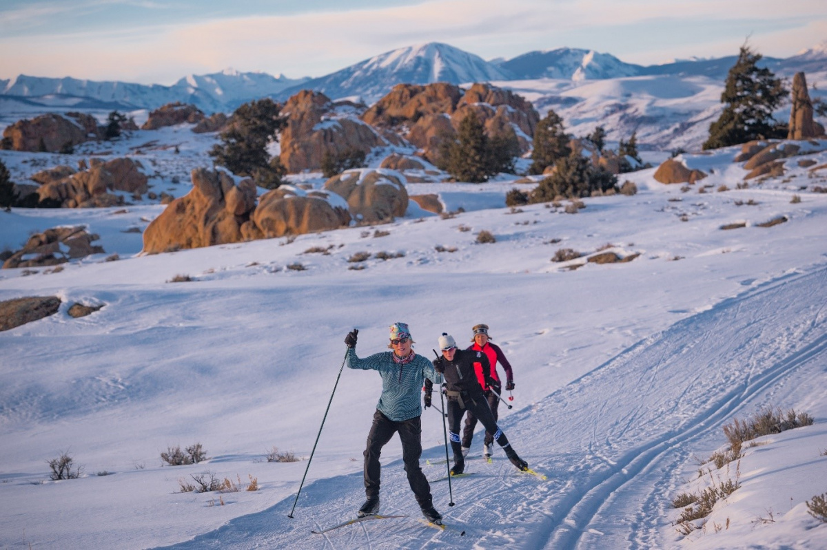 three individuals cross country skiing