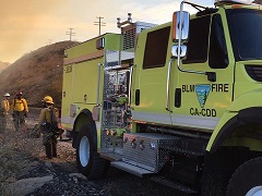 BLM fire engine in the haze of a desert fire. Photo by Paul Gibbs/BLM.