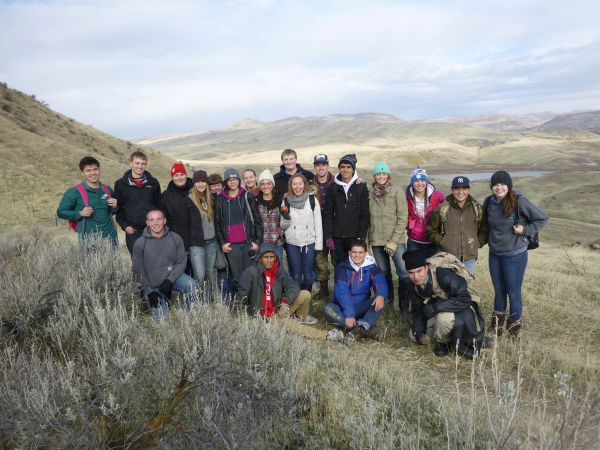 A group of people pose for a picture in the field.