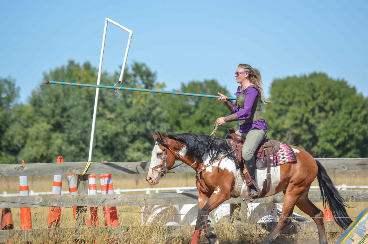 Woman jousting on a horse. 