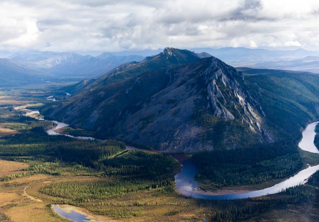 Aerial photo of a river going around a mountain