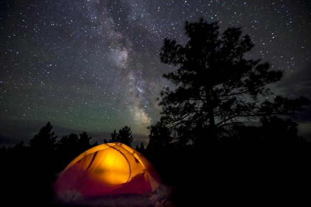 Tent illuminated against a starry night