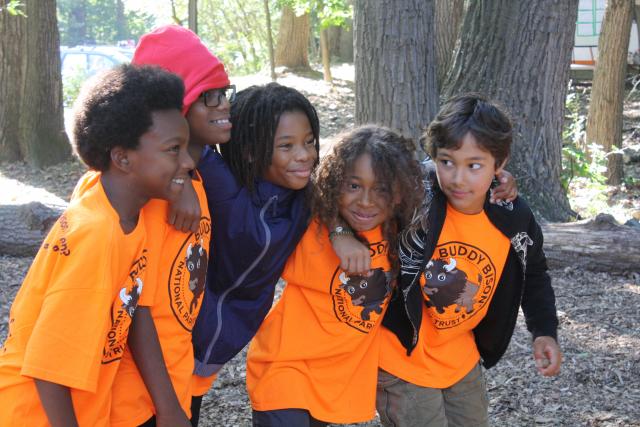 Five children embrace as they explore the outdoors