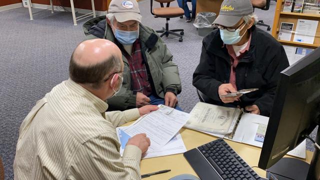 Three men looking at papers