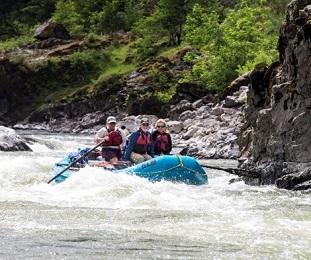 group of people floating in a boat on a river