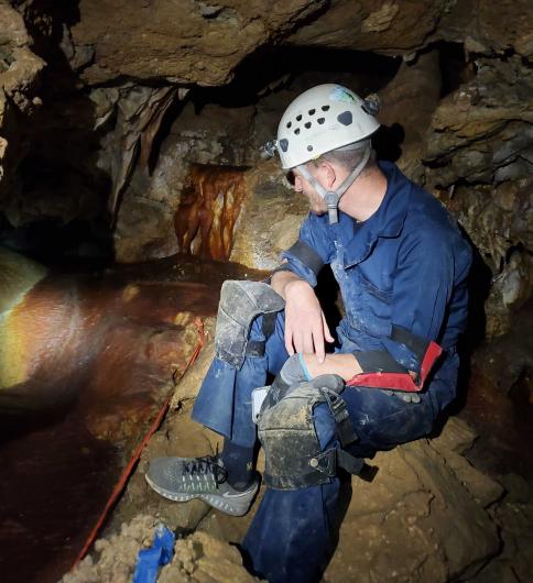 CFO staff member Bryce Franklin admires flowstone in Wind-Hicks.