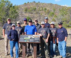 Mule Deer Foundation volunteers surrounding a newly installed interpretive sign