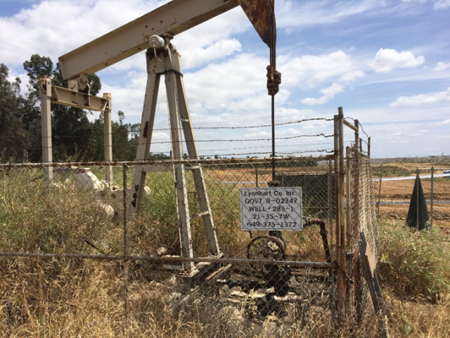 An abandoned well with vegetation growing through it