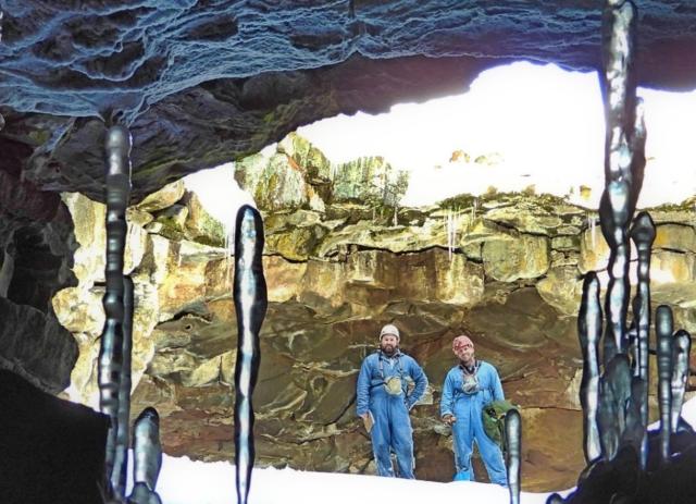 Two people at the mouth of a cave