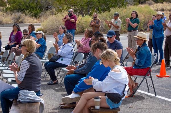 Attendees at the ceremony sit in chairs clapping