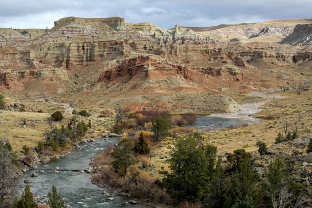 Scenic landscape of the Dubois Badlands Wilderness Study Area: red cliffs and a blue stream