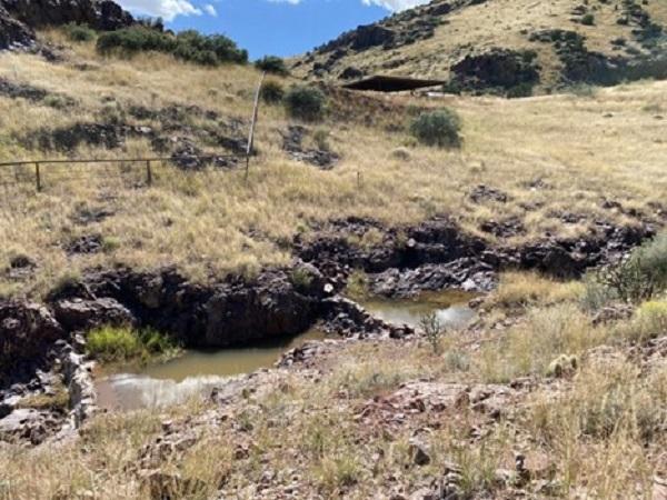 Natural pools surrounded by rocks and brown grass