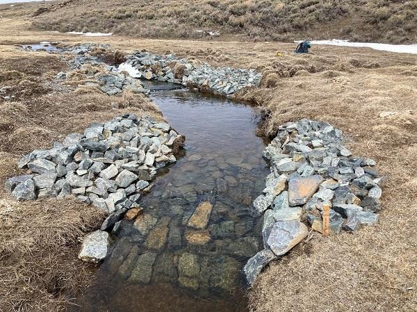 A view of a Zeedyk structure- gray rocks around a stream.