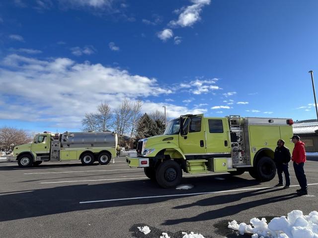 Chad and Nathan discuss interagency response in front of the transferred wildland fire engine and water tender