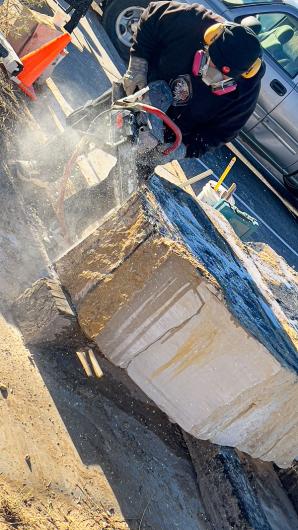 Walter Torres uses a high-powered wet saw to sculpt a slab of stone.  