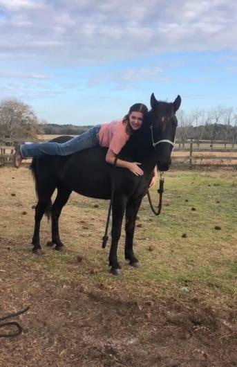 Girl on horse hugging neck. 