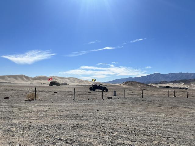 Buggies riding over sand dunes 