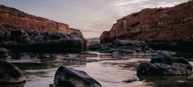 A river with rocks in it at dusk. 