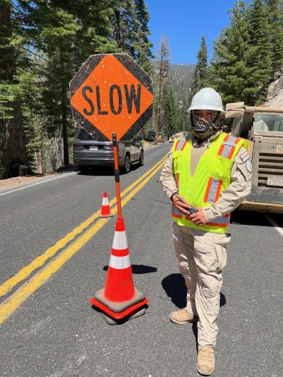 BLM Park Ranger Adrian Hernandez directs traffic during road maintenance.