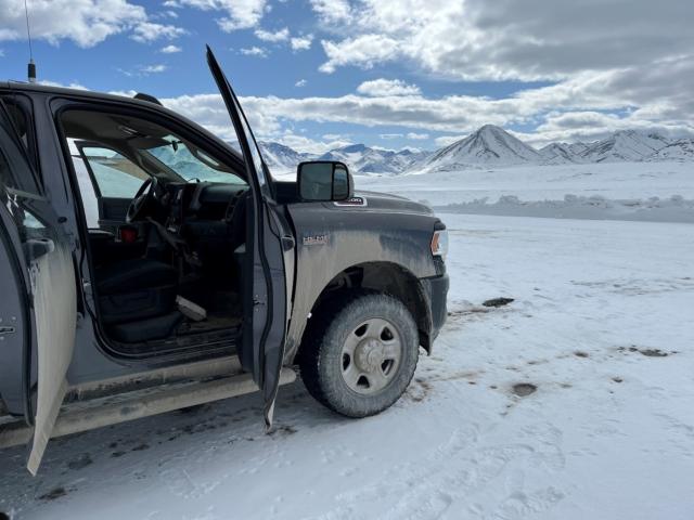 A pickup truck is pointed to look out across the Arctic landscape.