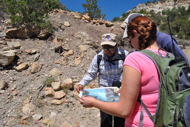 Hikers holding a map and getting ready to head out on a hike.