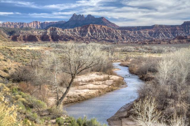 A river flowing through a landscape toward a mountain range.