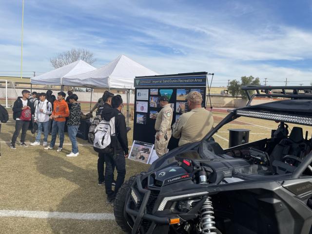 A group of BLM  employees stand in front of OHVs