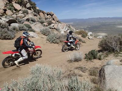 A dirt bike at the top of a high desert peak. 