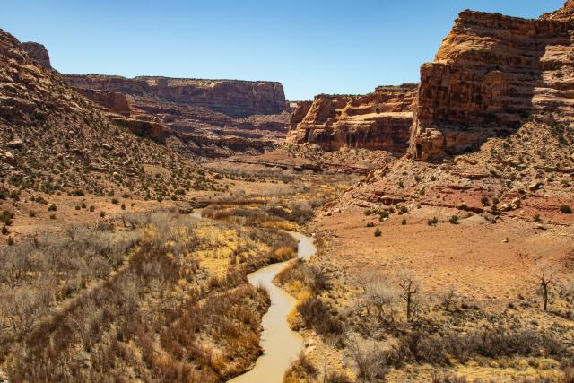 A running river through a valley surrounded by rock mountain formations.