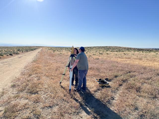 Sean Birt and daughter Dagny Birt using surveying equipment.