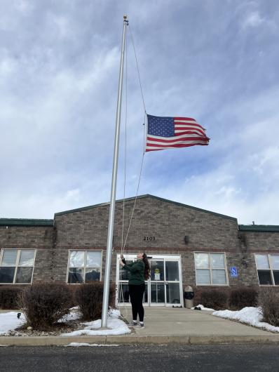 a woman raises a flag at a BLM office