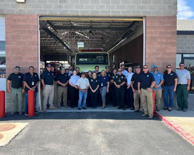 Ceremony attendees pose for a group photo in front of the water tender