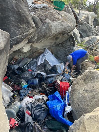 Alex Nancarrow disassembles the shelter and gathers trash. Photo by Mark Nebeker.