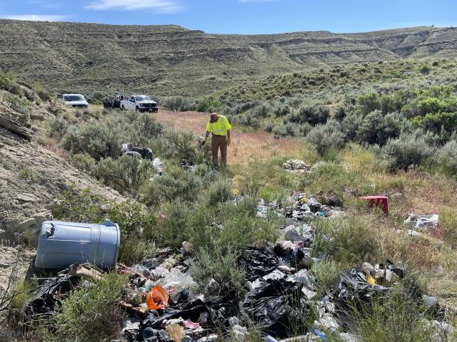 Person looks at trash spread widely across the ground