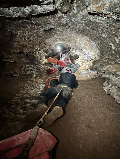 Capitan High School athletes drag packs of water through the “Hell Hole” passage within Fort Stanton Cave.