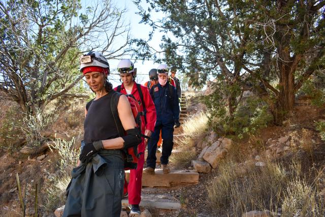 Carrin Rich, front, volunteer restoration coordinator for Fort Stanton Cave, leads Capitan HS athletes into the cave.