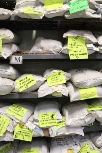 Plastic white sacks stacked and labeled with words and numbers