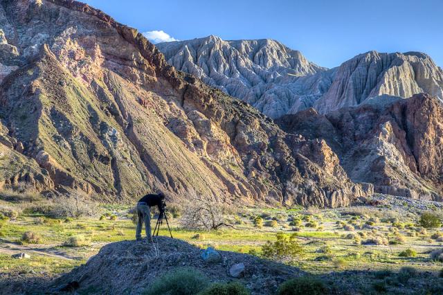 A photographer takes a photo of a majestic canyon