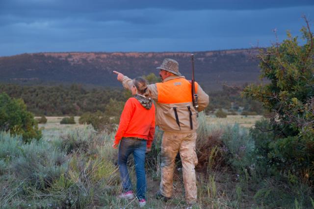 an older man teaches his granddaughter to hunt