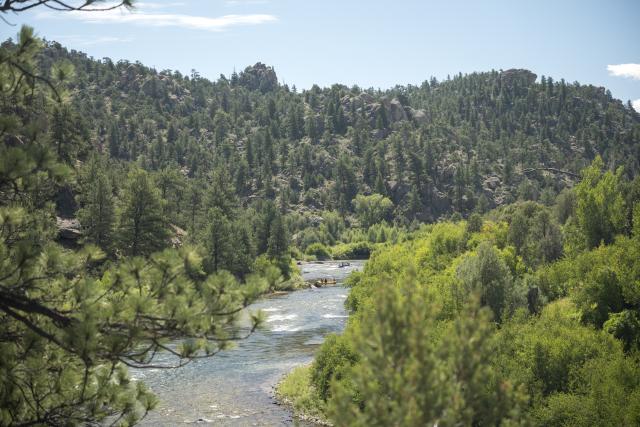 Rafters navigate the Arkansas River as it winds between the towering granite cliffs of Browns Canyon National Monument.