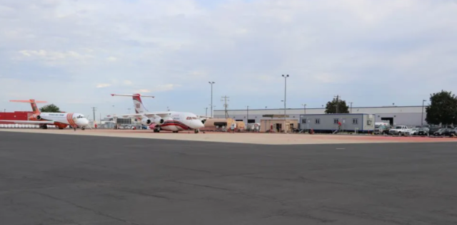 Airplanes parked on tarmac outside of a trailer