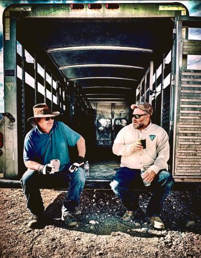 BLM staff Alex Neibergs and John Thomas sit in the back of a horse trailer