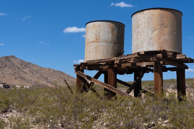 Two water towers along a trail.