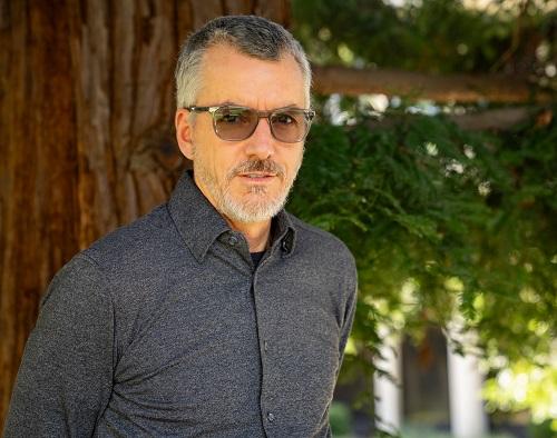 Mark Kougl Headshot. A man in a gray shirt and glasses.