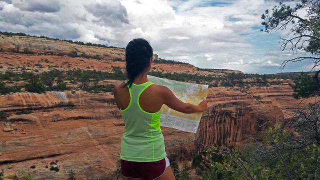 person reading a map with view of mule canyon in the background