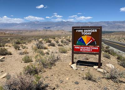 A sign in the desert indicating high fire danger.