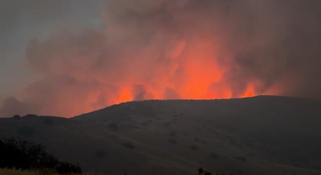 flames burn red through dark smoke