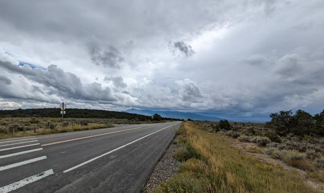 Driving down the Wild Rivers Scenic Backcountry Byway underneath a cloudy sky.