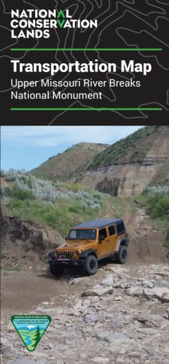 Photo of the cover of the Upper Missouri River Breaks National Monument Transportation Map showing a photo of a SUV traversing a primitive road on a rocky hillside.